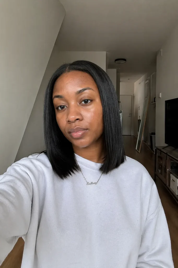 blunt cut long bob hairstyle and straight natural hair, featuring thick sharp ends and a relaxed neutral expression