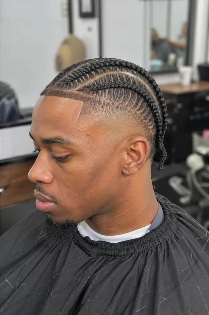 realistic barbershop scene showing a Black man with neatly styled stitch braids and a burst fade haircut, seated in a barber chair with a calm