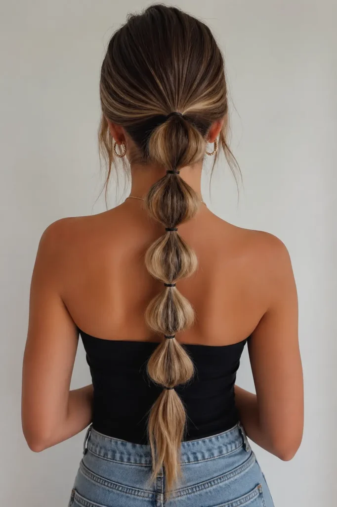 a young woman with a sleek bubble ponytail featuring evenly spaced, voluminous sections secured with bands.