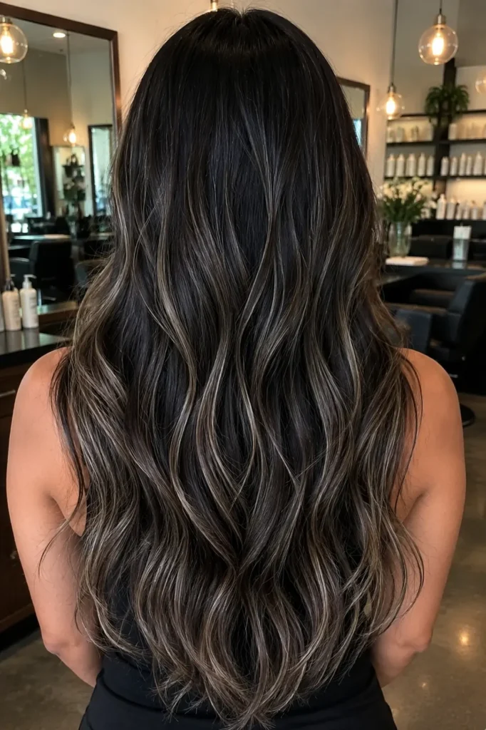 girl with long dark hair featuring cool ash money-piece-inspired babylights blended into soft layered waves