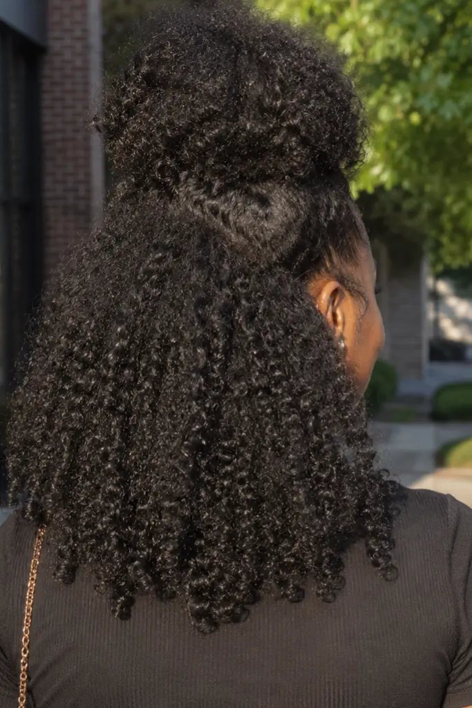 a back side of girl has Curly High Puff Half Up Half Down Style 