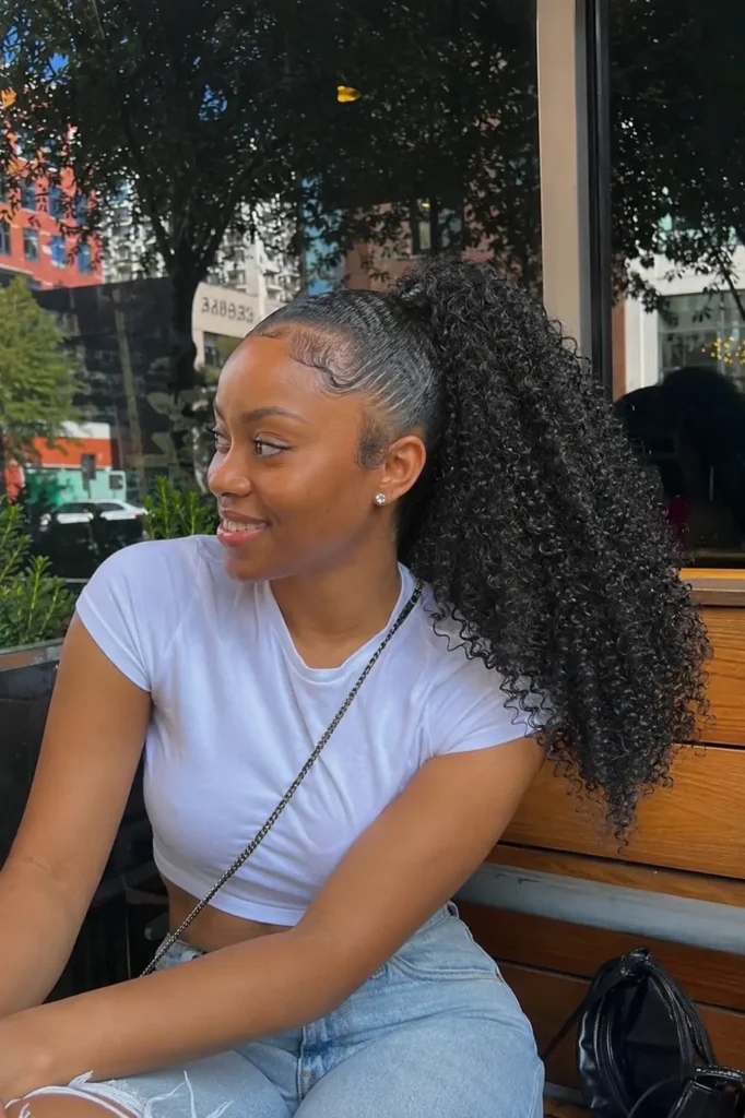 Young woman with an extra curly textured quick weave ponytail featuring tightly defined, voluminous curls with natural movement, realistic skin texture and authentic facial features, wearing a casual outfit