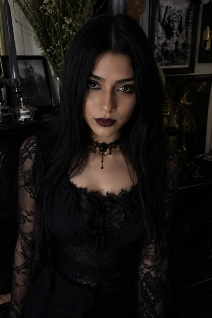 young girl with sleek jet-black straight hair and a middle part, wearing a black lace gothic outfit and dark elegant makeup in moody low lighting
