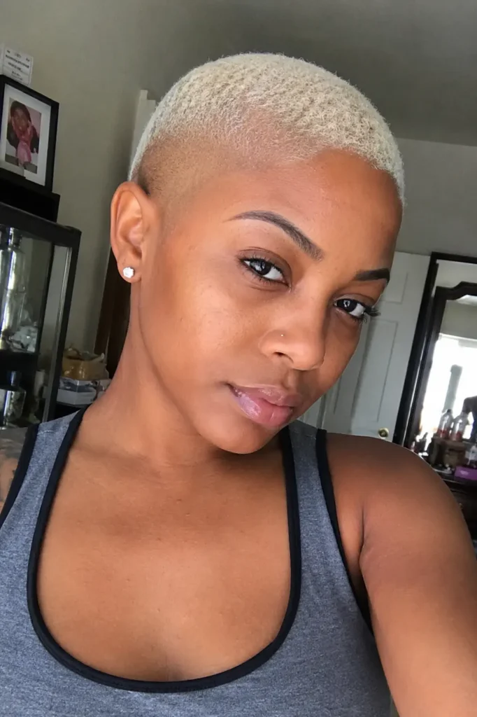 a Black woman aged around 25–35 with a platinum bald fade hairstyle, featuring authentic facial features,