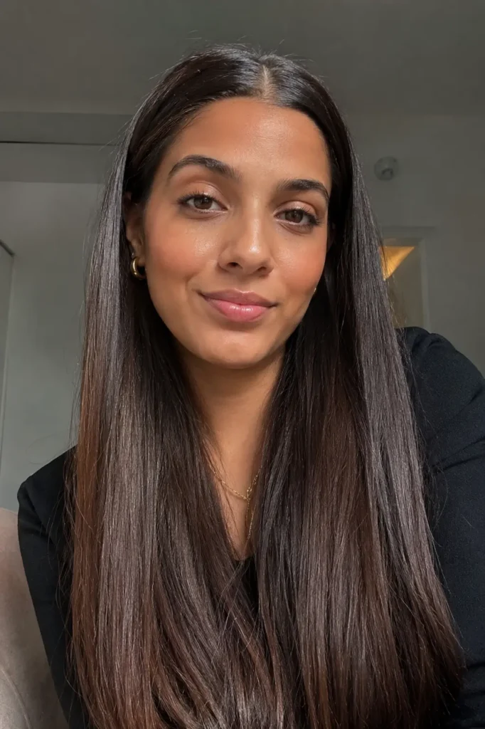 a young woman with sleek straight hair and slicked front styling, featuring shiny smooth texture,