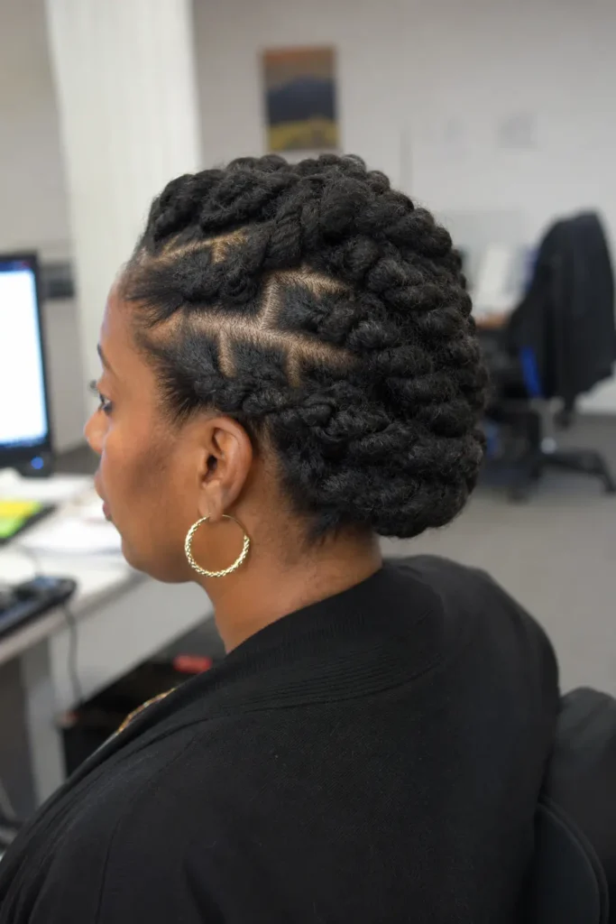everyday woman with natural Type 4 hair styled in jumbo flat twists, photographed from the side and back in a professional office setting. The detailed twist pattern is clearly visible, showcasing the texture and structure of the hairstyle.