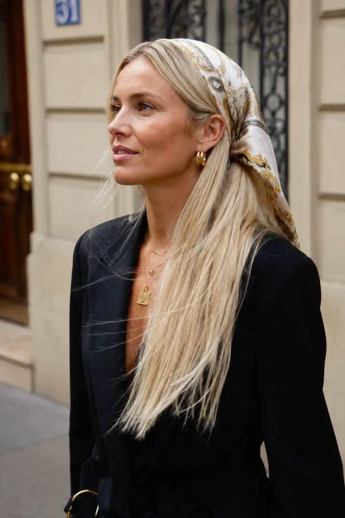 English woman with long straight platinum blonde hair styled with an elegant silk bandana, photographed outdoors in natural daylight