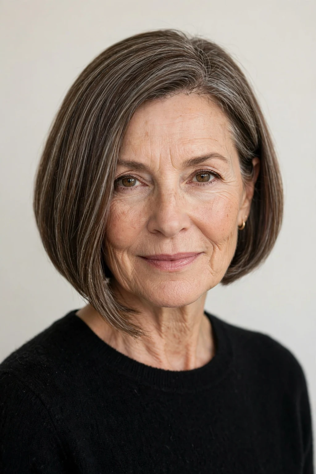 Elegant woman over 50 with a-line bob, angled modern shape, confident light.