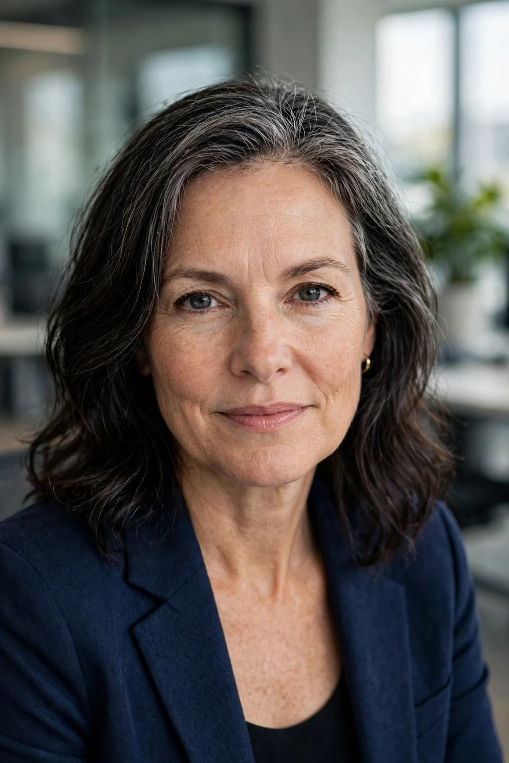 Beautiful woman with dark hair and blended gray roots, soft gray root blend, natural light.