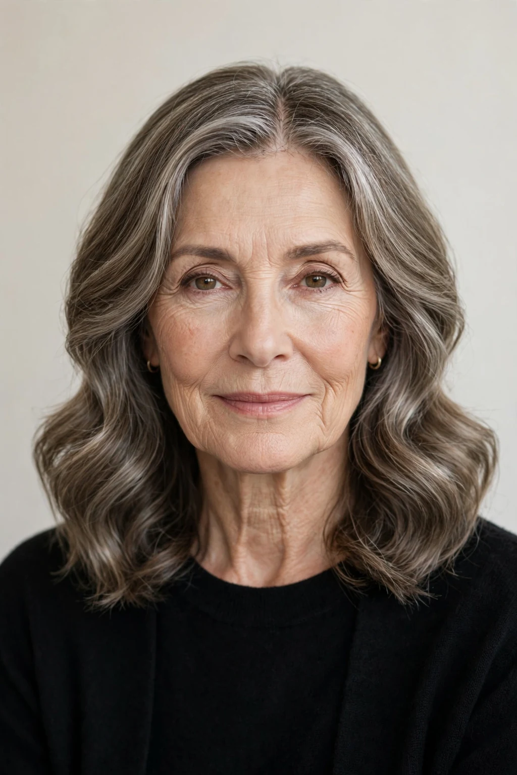 Elegant woman over 60 with center-part soft waves, balanced serene style, calm light.