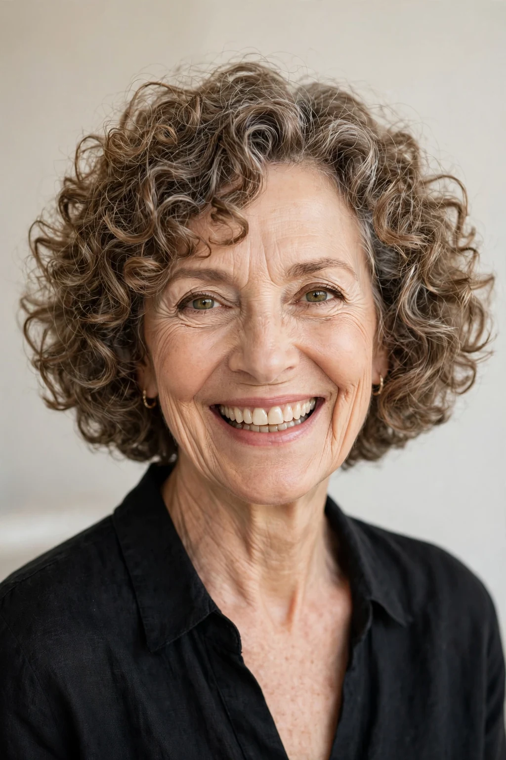 Elegant woman over 60 with curly bob, bouncy defined curls, joyful light.