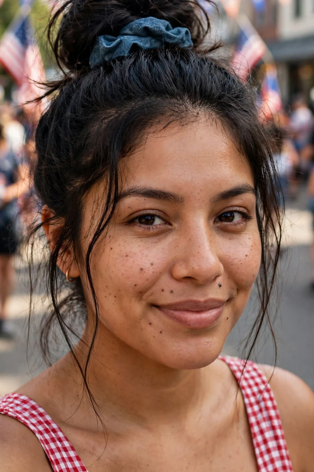 Young woman with a denim blue scrunchie high bun at a summer parade.