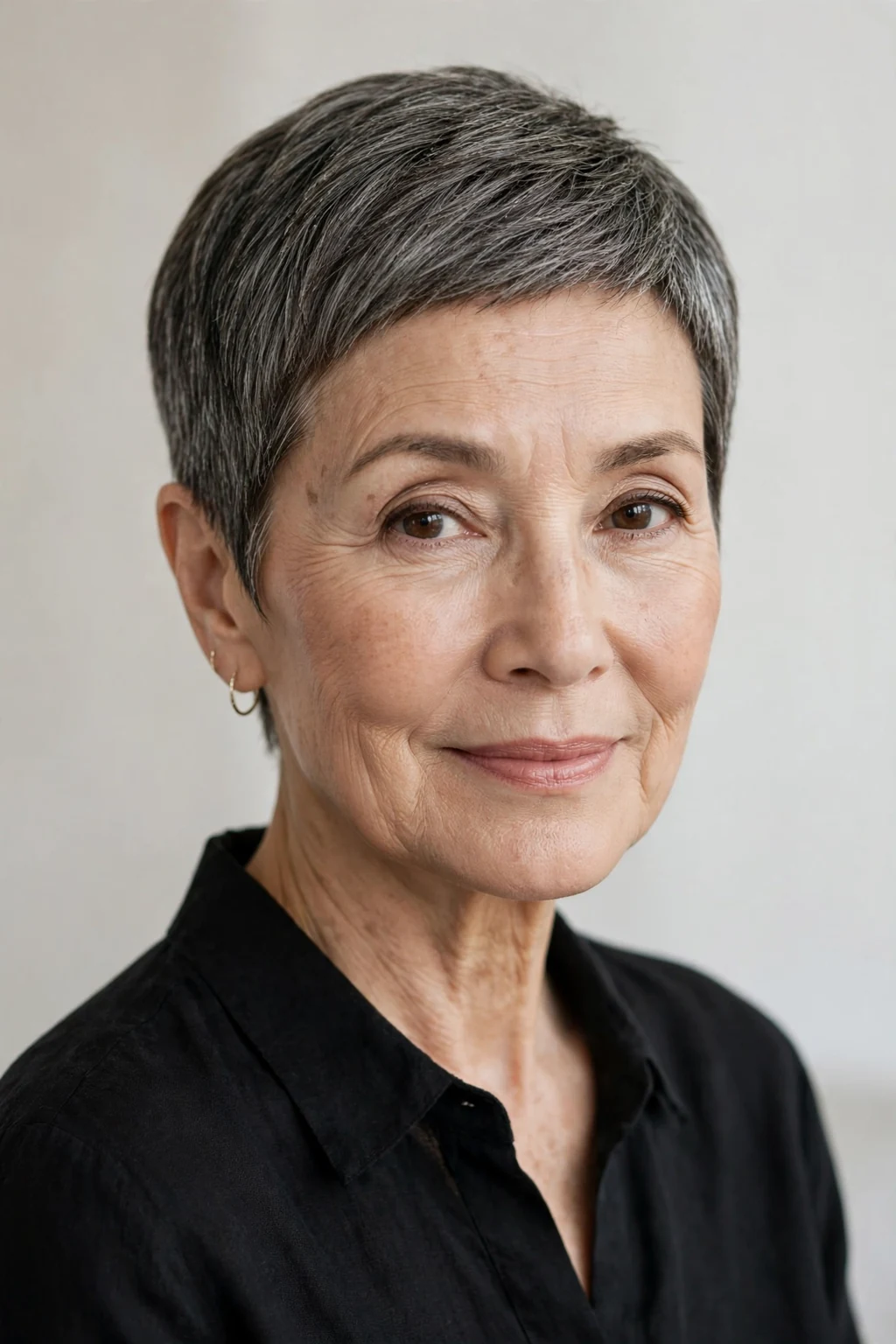 Elegant woman over 60 with elegant cropped cut, refined short shape, sophisticated light.