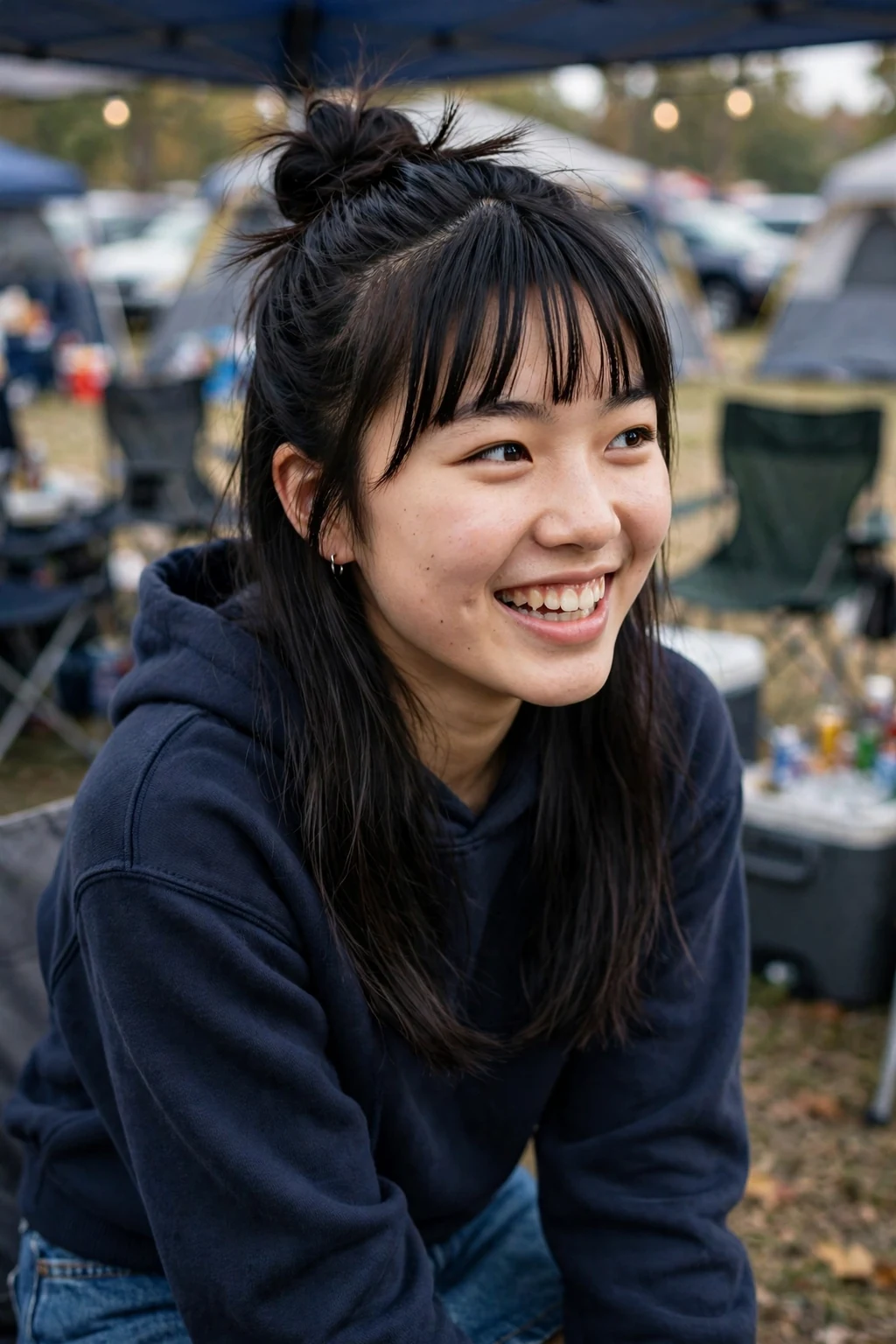 Young woman tailgating in a team hoodie with a half-up top knot and loose waves.